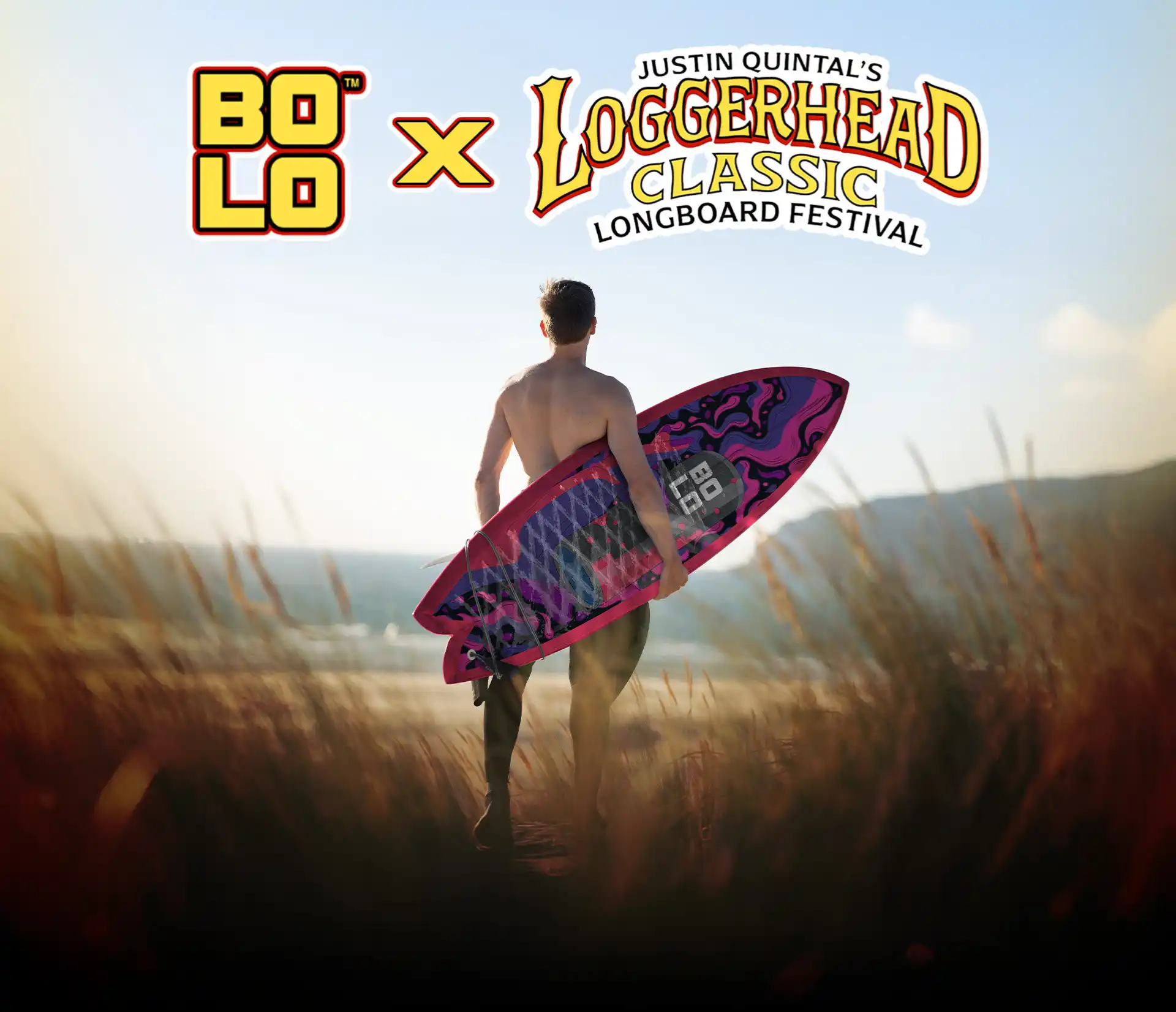 BOLO x Loggerhead Classic Longboard Festival - Surfer holding a BOLO surfboard in sandy dunes while looking out at the ocean.